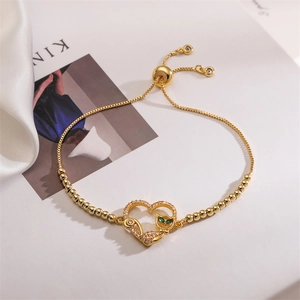 Détail d'un bracelet coeur doré ajustable avec chat en zircon et yeux émeraude