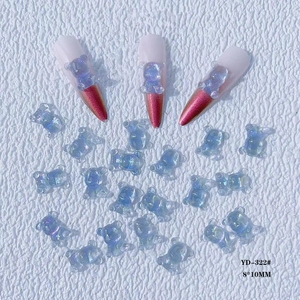Macro shot of 8x10mm ice blue resin bear nail charms and manicure design on white background