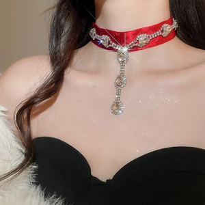 Détail macro du choker en velours avec strass brillants et cristaux en goutte d'eau