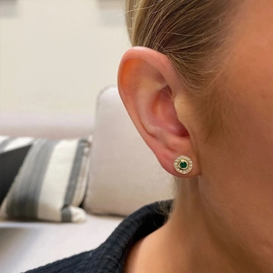 Close-up of S925 silver stud earring with emerald gemstone on model's ear