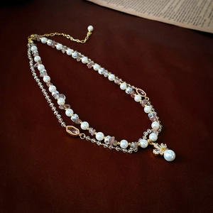 Double-layered pearl and crystal necklace featuring a golden floral pendant for women