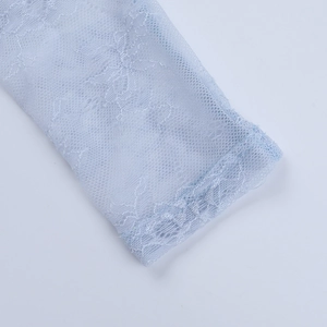Vue macro du motif de dentelle florale bleu clair et de la texture de maille complexe