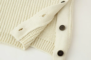 Detailed macro shot of rib-knit fabric side slit with three vintage bronze metal buttons