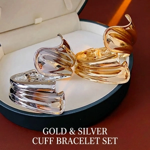 Irregular wavy metal cuff bracelets in gold and silver finish with high-gloss reflection