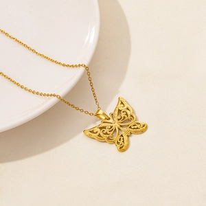Detailed close-up of a golden stainless steel butterfly pendant with intricate cutout patterns