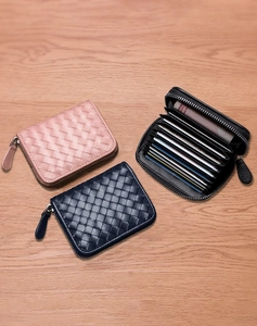 Detail view of woven leather card holders in pink, navy, and black with multi-slot interior