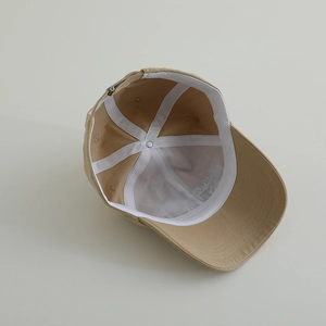 Interior detail of khaki cotton baseball cap showing 6-panel structure and seams