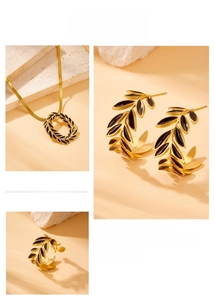 Detailed close-up of golden laurel leaf jewelry set with black enamel accents