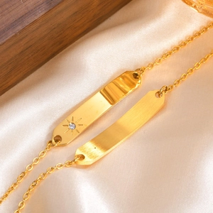 Detail showing gold bar bracelets with sunburst engraving and zircon on champagne silk