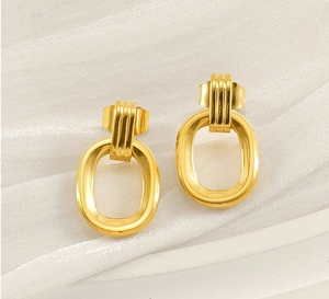 Gros plan de boucles d'oreilles ovales plaquées or avec détails de texture rayée verticale