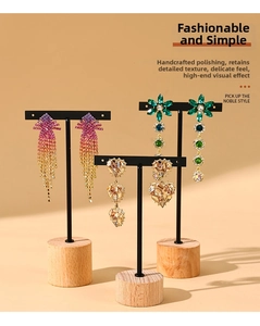 Detailed view of three pairs of elegant tassel and crystal earrings on wooden stands