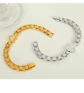Macro detail of gold and silver heart bracelets with roman numeral shell inlay