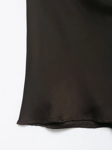 Detail view of smooth dark brown satin fabric texture with fringe trim and hem stitching