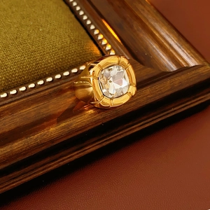 Dettaglio macro di un anello vintage dorato con un grande zircone a taglio quadrato