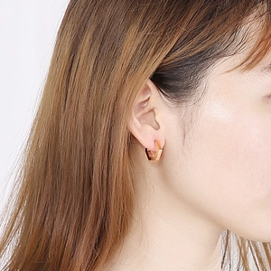 Boucles d'oreilles créoles hexagonales en or rose portées par un mannequin