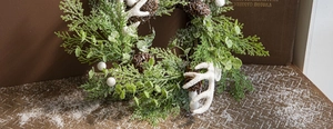Detailed view of snowy white antlers and pine cones on a Christmas wreath decoration