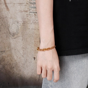 Close-up of a chunky gold Cuban chain bracelet on wrist for a bold street style look