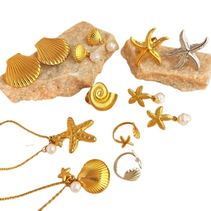 Set gioielli dorati serie oceano con stelle marine, conchiglie e perle bianche