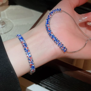 Détail d'un bracelet réglable en argent avec maillons en émail coloré sur un poignet