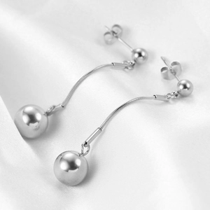 Detail of silver drop earrings with sleek snake chain and polished 10mm metal spheres
