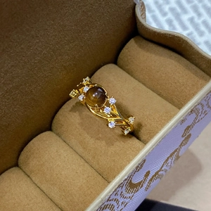 Elegant gold-plated ring with round tiger eye stone and white zircon in a brown jewelry box