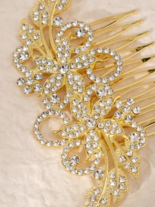 Detailansicht eines goldenen Haarkamms mit floralen Mustern und funkelnden Strasssteinen