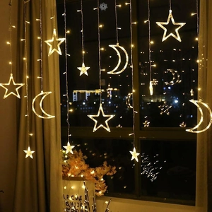 Solar powered star and moon LED curtain lights with warm yellow glow for window decor