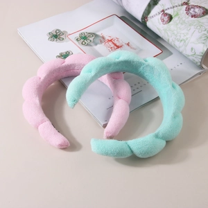 Detailed view of pink and green wave textured terry cloth headbands on an open magazine