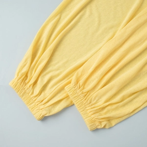 Detail of the elasticized cuffs on light yellow summer beachwear knit trousers