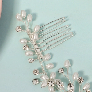 Elegant bridal hair comb with pearls and rhinestones on a serene blue backdrop