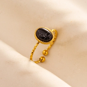 Macro shot of gold stainless steel adjustable ring with oval black marble stone