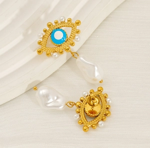 Macro shot of evil eye stud earring with vibrant blue enamel and a baroque pearl drop