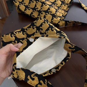 Vue détaillée du sac en toile avec imprimé éléphant doré et fermeture à bouton aimanté