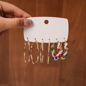 Détail de trois paires de créoles avec texture dorée torsadée et perles fantaisie