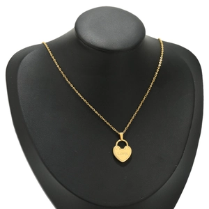 Polished gold heart lock pendant necklace with LOVE engraving on black jewelry bust