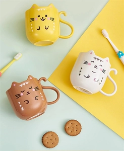 Three cute cartoon cat-shaped plastic toothbrushes mugs in yellow, white, and brown colors