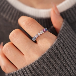 Close-up of 18k gold plated ring with colorful zircon floral pattern on a grey knit sleeve