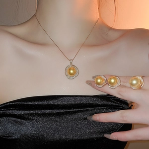 Gros plan sur l'ensemble bijoux de perles dorées avec collier, boucles et bague
