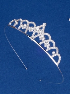 Close-up of silver tiara with white rhinestones and wave patterns on blue background