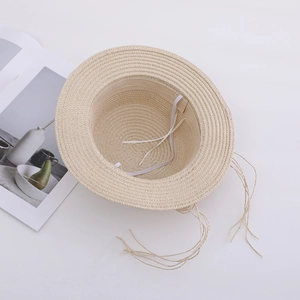 Girls straw sun hat with wide brim and tassel details on white background for beach trips