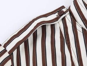 Detailed close-up of brown striped shirt shoulder epaulet with a dark brown button