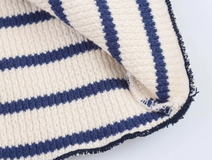 Detailed close-up of navy and cream striped knit fabric texture and weaving process