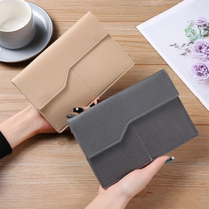 Detail view of khaki and dark grey PU leather passport organizers on a wooden table
