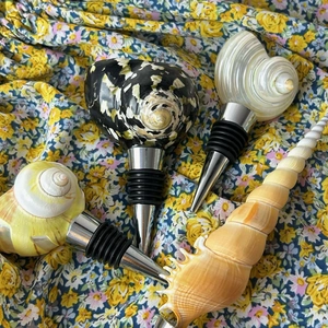 Detail showing four assorted natural seashell wine bottle stoppers with silicone seals