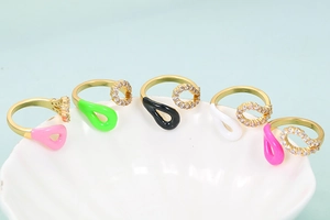 Macro view of five 18K gold plated open rings with colorful enamel drops and zircons