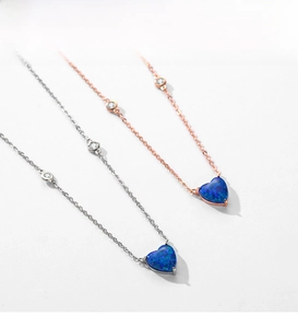 Detail of S925 silver and rose gold necklaces featuring heart-shaped blue opal pendants