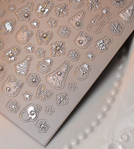 Detailed macro view of 5D embossed Christmas nail stickers with silver snowmen and rhinestones