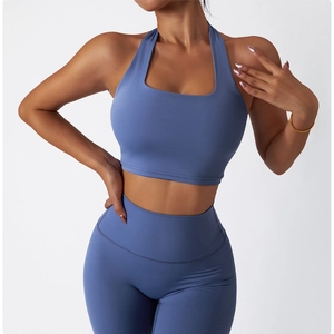 Detail of foggy blue high-waist yoga pants and halter sports bra set with matte texture
