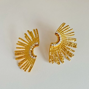 Macro shot of 18k gold plated sunburst earrings with sparkling zircon inlay details