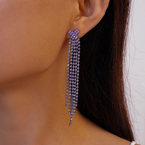Close-up of elegant purple rhinestone tassel earrings worn by a model in detail